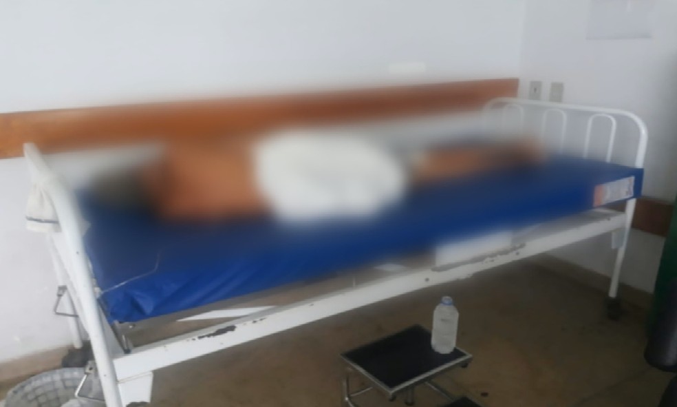 Paciente deitado em maca sem lençol em unidade de saúde de Goiânia, Goiás — Foto: Reprodução/TV Anhanguera
