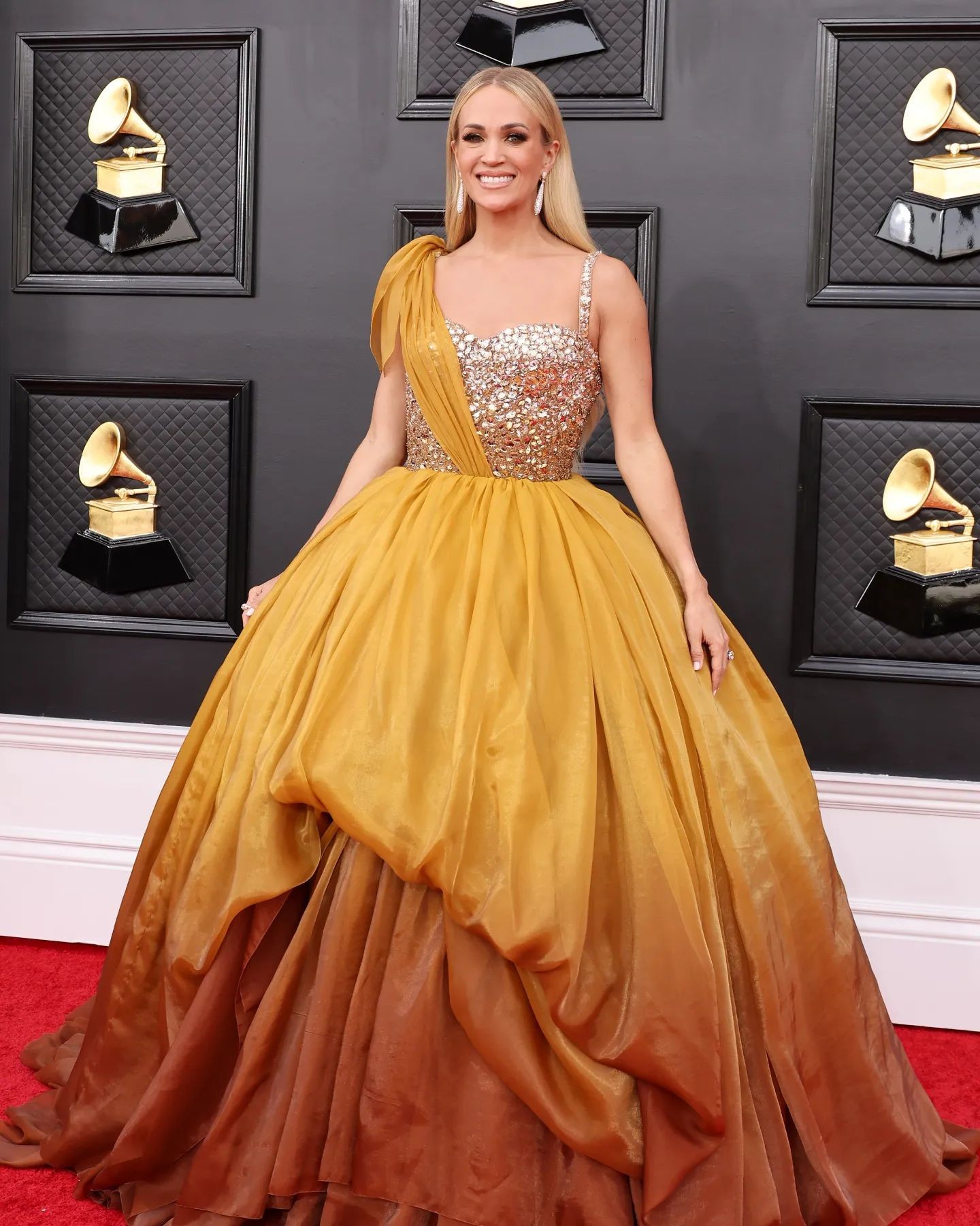 Carrie Underwood apareceu com vestido longo e em tom de amarelo dourado (Foto: Reprodução / Getty Images)