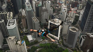 Base jumper Chris Mcdougall, da Austrália, pula do deck aberto de 300 metros de altura da Torre de Kuala Lumpur, ponto turístico da Malásia — Foto: MOHD RASFAN/AFP