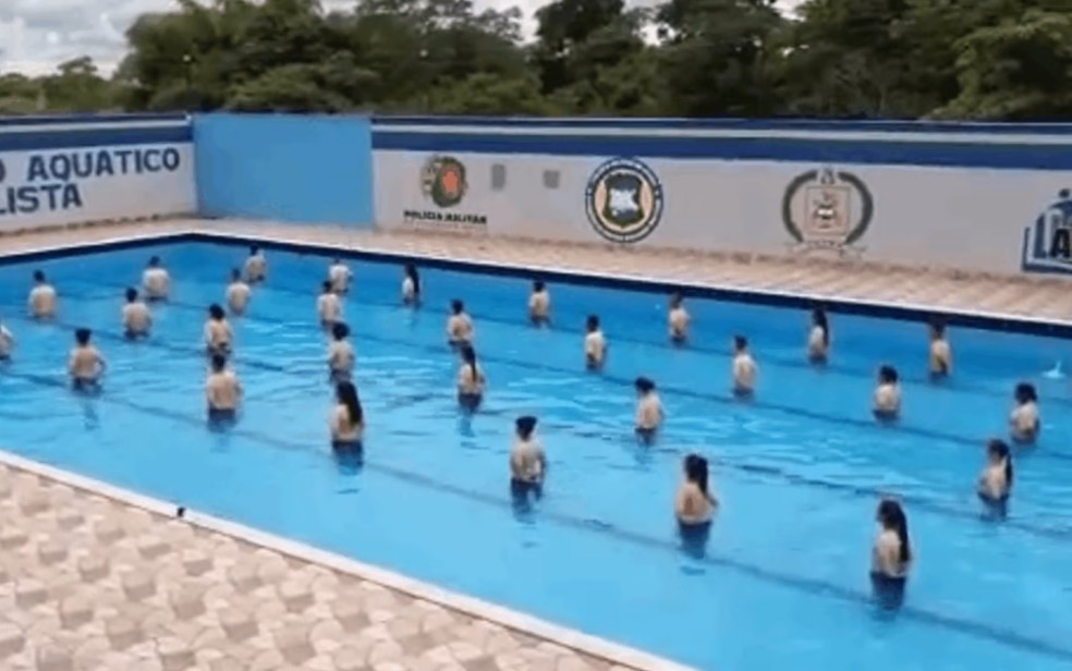 MP apura vídeo que mostra alunos de colégio militar dentro de piscina idolatrando funcionário em Aparecida de Goiânia, Goiás — Foto: Reprodução/TV Anhanguera