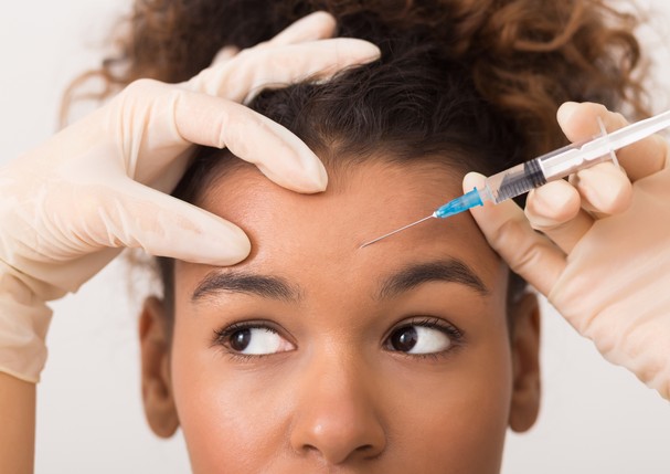 Cosmetic procedures. African-american woman getting botox injection in forehead (Foto: Getty Images/iStockphoto)