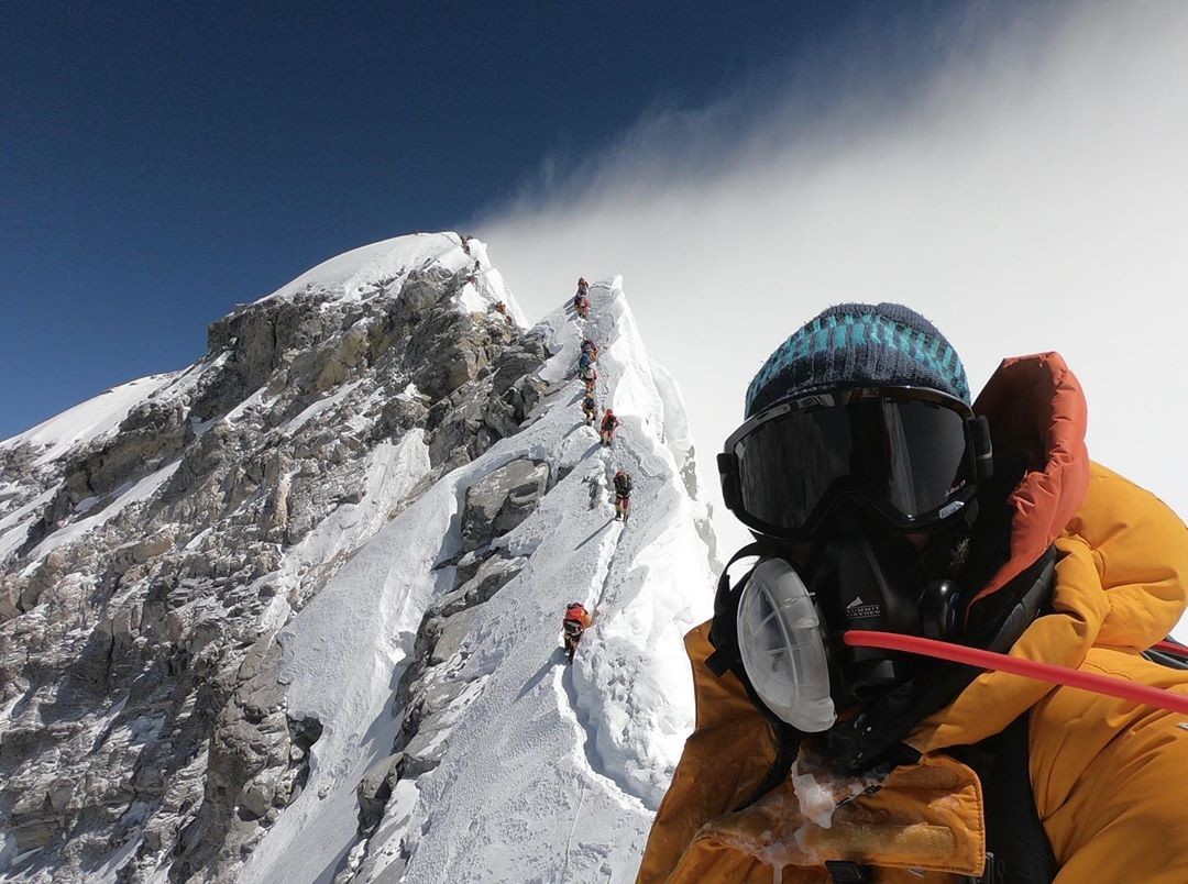 O montanhista brasileiro Moeses Fiamoncini em uma selfie com o cume do Everest ao fundo (Foto: Reprodução/Instagram)