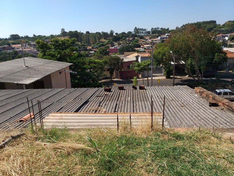Terreno da rua de cima, que faz divisa com o imóvel, fica exatamente no mesmo nível do telhado — Foto: Heloise Hamada/G1