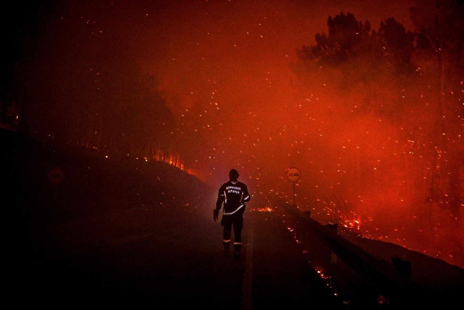 Bombeiro caminha por uma estrada durante um incêndio florestal em Manteigas, centro de Portugal, em 10 de agosto. — Foto: PATRICIA DE MELO MOREIRA / AFP