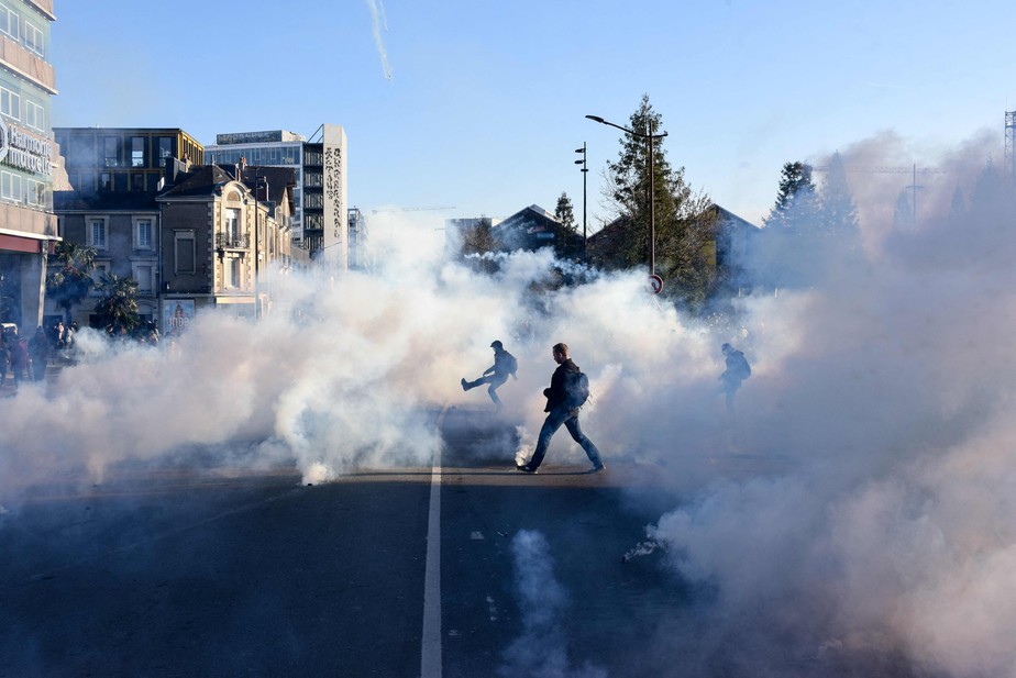 Manifestante usa bomba de gás lacrimogêneo durante confrontos no quarto dia de manifestação contra a reforma de previdência no país