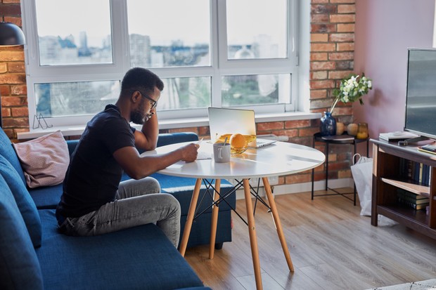 portrait of young african man concentrated on work at home, hardworkng guy sit reading document, he is on freelance, in the morning (Foto: Getty Images/iStockphoto)