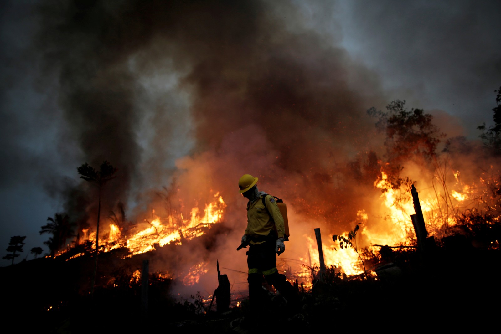 Membro da brigada de incêndio do Instituto Brasileiro do Meio Ambiente e dos Recursos Naturais Renováveis (Ibama) tenta controlar um incêndio em uma área da floresta amazônica, em Apuí, no AmazonasREUTERS