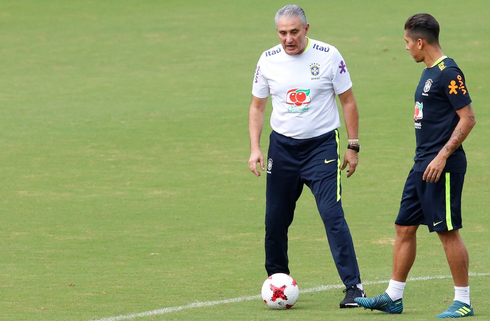 Tite conversa com Firmino, substituto de Gabriel Jesus no momento: treinador pretende testar outros nomes para o setor (Foto: Reuters)