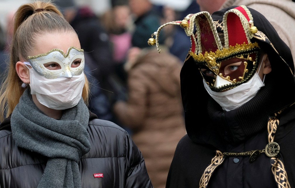 Foliões usam máscaras de proteção em Veneza, que teve os festejos cancelados por causa de um surto de coronavírus. — Foto: Manuel Silvestri/Reuters