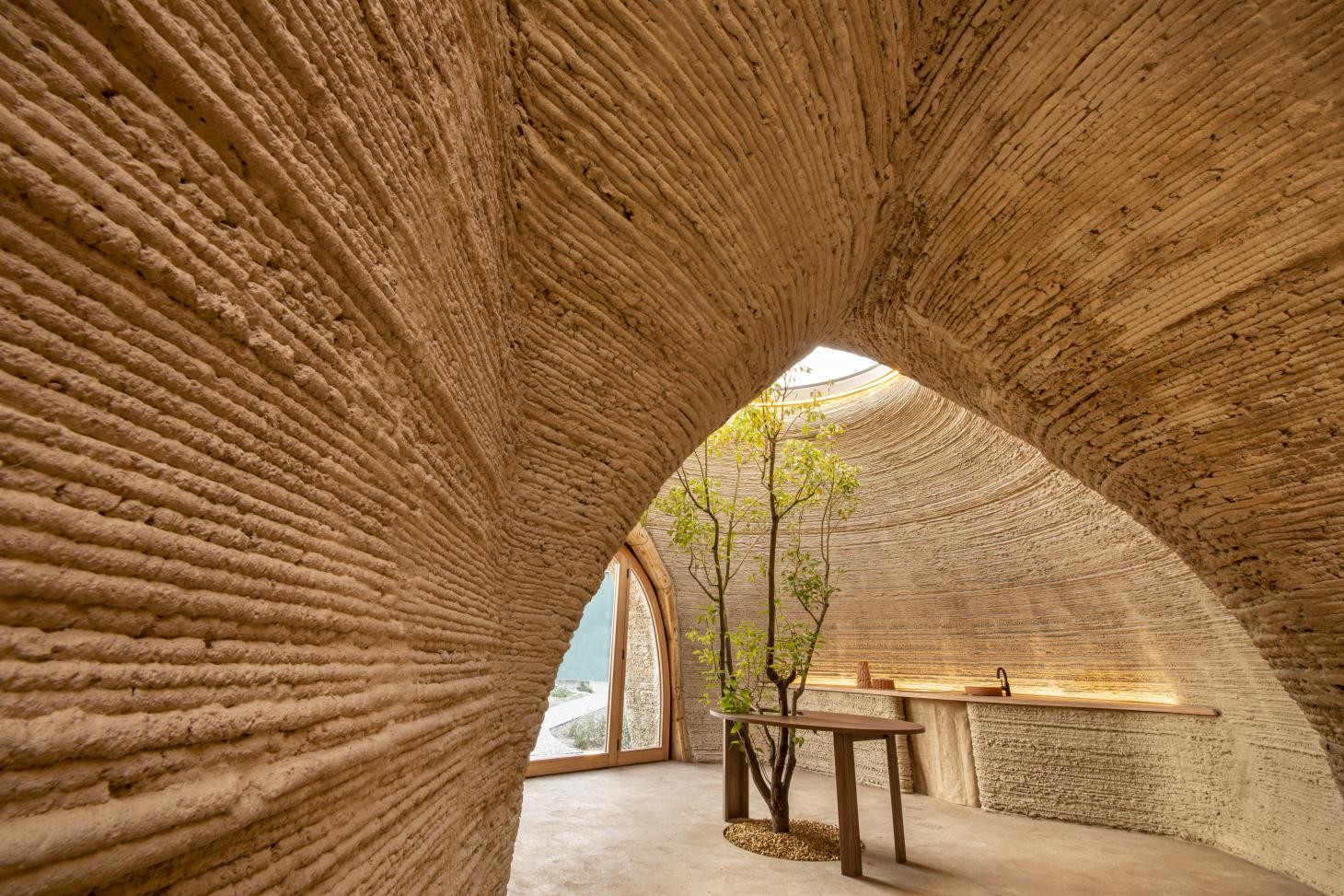 O escritório Mario Cucinella Architects construiu a primeira casa impressa em 3D do mundo feita inteiramente de terra crua, batizada de 