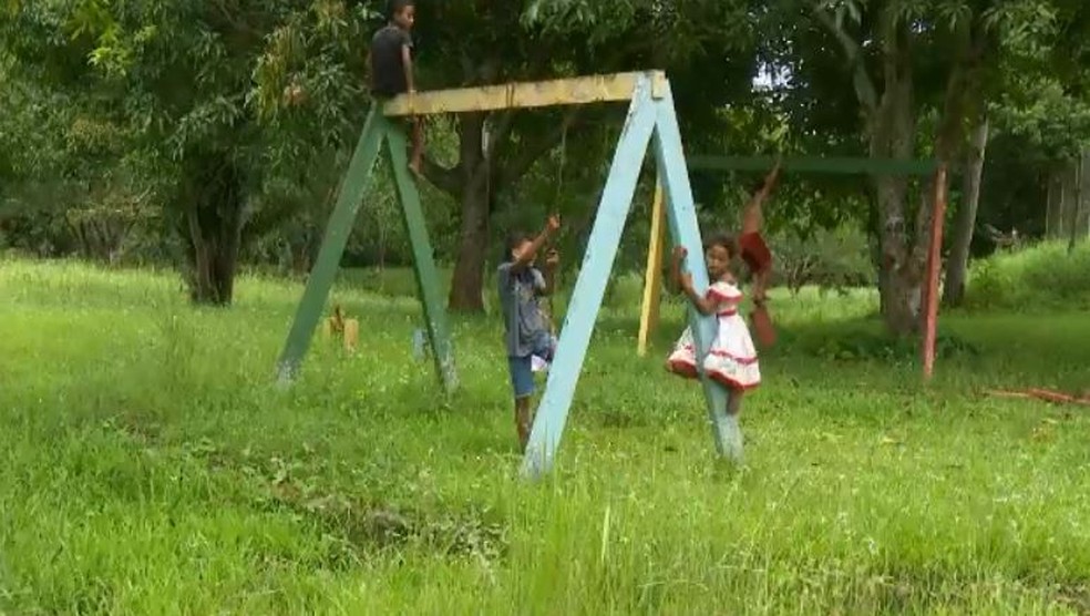 Crianças brincam com podem em brinquedos sucateados de parque abandonado (Foto: Reprodução/Rede Amazônica Acre)