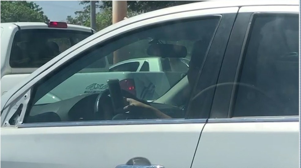 Motorista usa volante para apoiar celular enquanto dirige ...