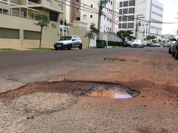 Motoristas precisam seguir na contramão para desviar de buracos na Rua Magda Perona Frossard, em Ribeirão Preto (Foto: Thaisa Figueiredo/G1)