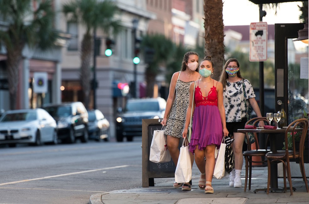 Pessoas caminham com máscaras em Charleston, Carolina do Sul, nos Estados Unidos, nos sábado (18)  — Foto: Sean Rayford / Getty Images / AFP