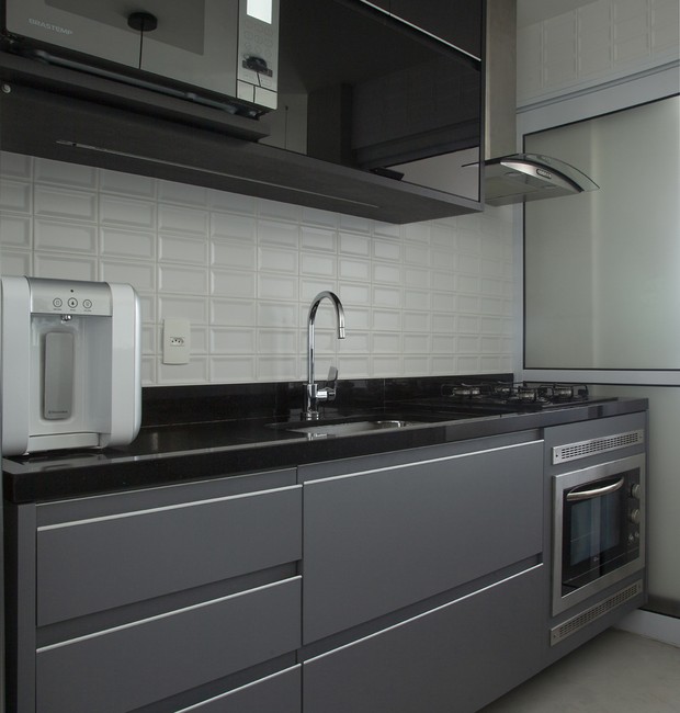 Na parte interna da cozinha, os armários seguem o mesmo estilo área que visa visível da sala (Foto: Luis Gomes / Divulgação)