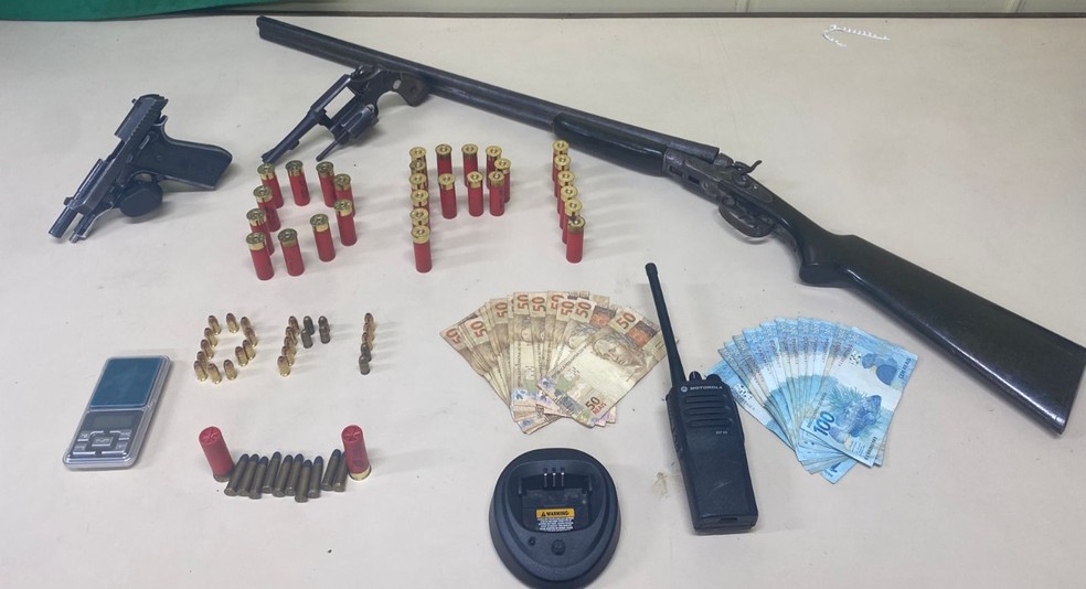 Uma pistola, um revólver calibre 38, uma espingarda calibre 16, munições e dinheiro foram apreendidos na embarcação. — Foto: Divulgação/Polícia Civil
