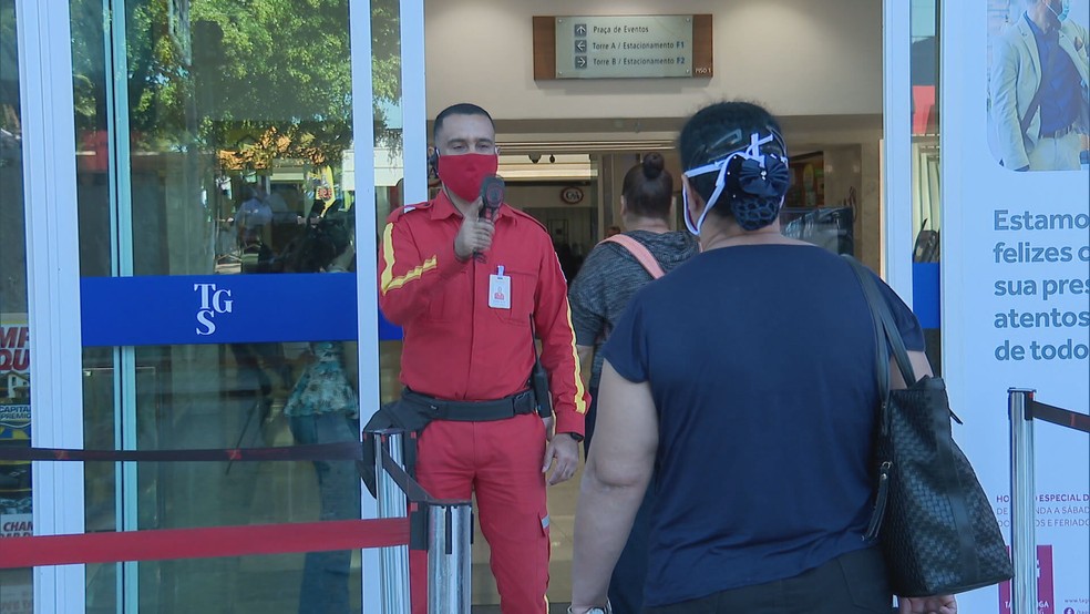 Shoppings são reabertos em Taguatinga, no Distrito Federal, com medição de temperatura na entrada — Foto: TV Globo/Reprodução 