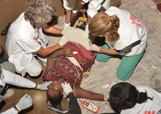 Mulher é socorrida por integrantes dos Médicos Sem Fronteiras após desabamento em Nairobi, no Quênia (Foto: Tony Karumba/AFP)