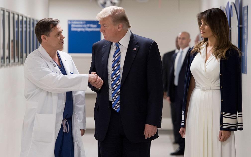 Ao lado da primeira-dama, Melania, o presidente dos EUA, Donald Trump, cumprimenta o médico Igor Nichiphorenko durante visita ao Hospital Broward Health North, onde visitou vítimas do ataque à Marjory Stoneman Douglas High School, em Parkland, na Flórida, na sexta-feira (16) (Foto: Jim Watson/AFP)