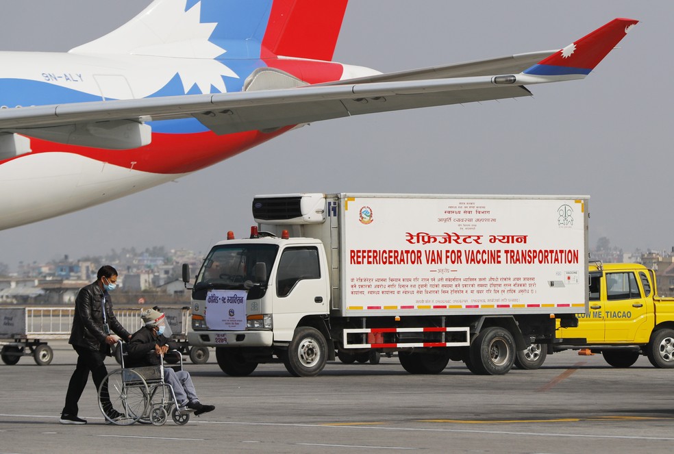 Van aguarda no aeroporto internacional de Catmandu para transportar as doses da vacina de Oxford/AstraZeneca contra a Covid-19 que a Índia doou para o Nepal — Foto: Niranjan Shrestha/AP
