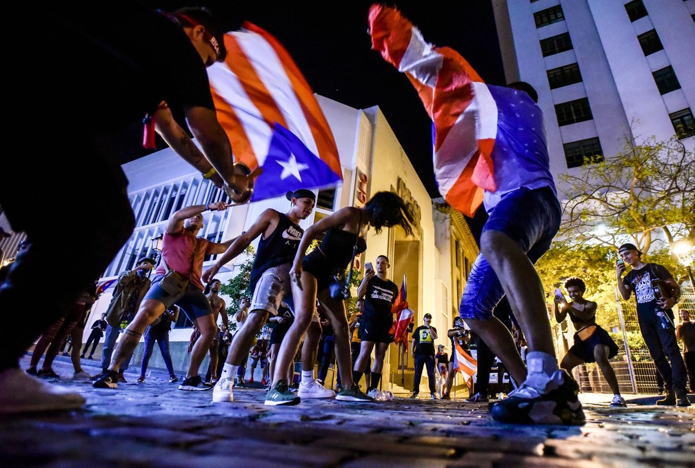 Porto-riquenhos comemoram o anúncio da renúncia do governador Ricardo Rossello na quinta-feira (25)  — Foto: Carlos Giusti/AP