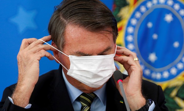 Bolsonaro se atrapalha com máscara em entrevista sobre o coronavírus