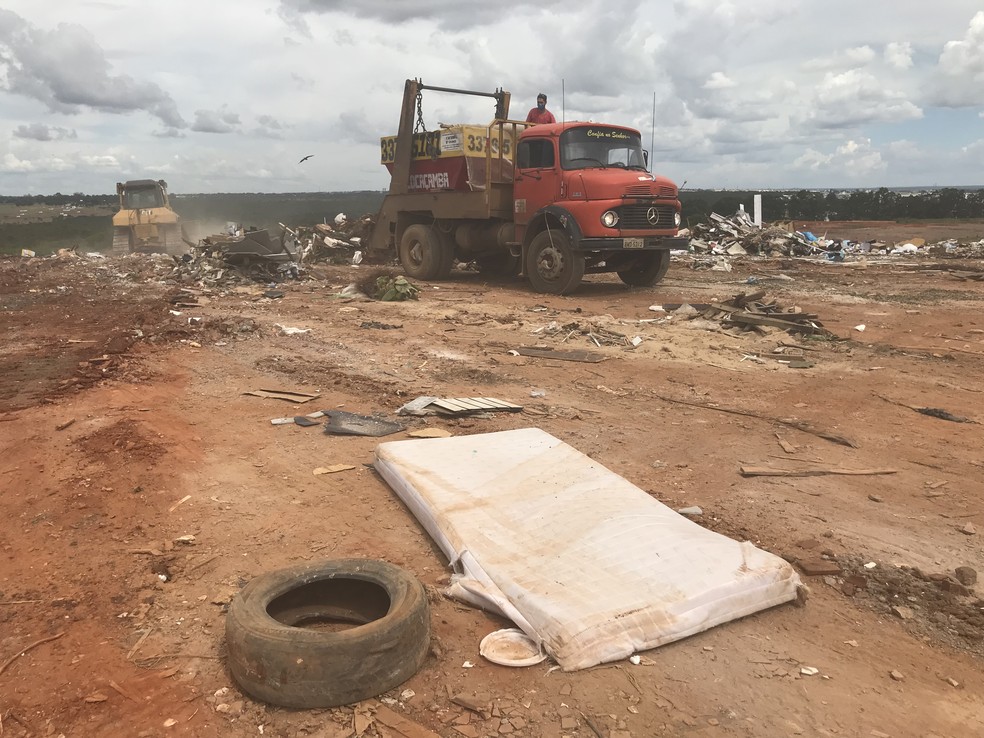 Caminhão descarrega contêiner de com rejeitos da construção civil no antigo Lixão da Estrutural — Foto: Marília Marques/G1