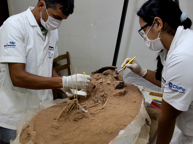 Arqueólogos trabalham em laboratório na escavação de uma criança enterrada há cerca de 3.500 anos no Piauí (Foto: Pedro Santiago/G1)