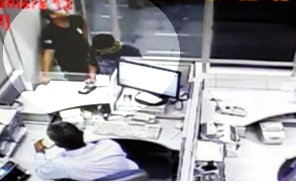 Preso é levado para sacar dinheiro em agência bancária escoltado por agente (Foto: TV Anhanguera/Reprodução)