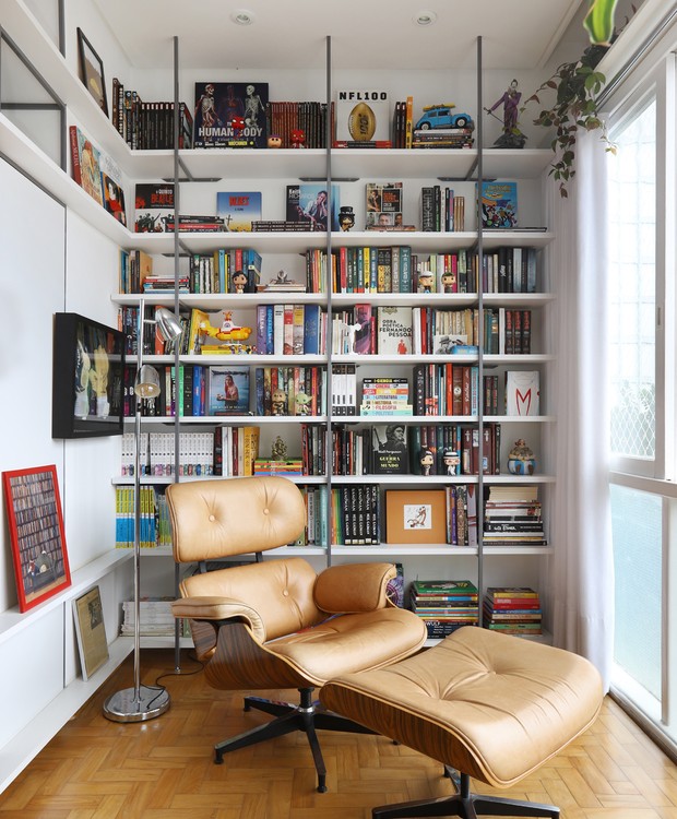 No ambiente projetado pelo escritório Oliva Arquitetura, a potlrona Eames Lounge Chair, de Ray e Charles Eames, com espaldar alto, é perfeita para leitura (Foto: Mariana Orsi / Divulgação)