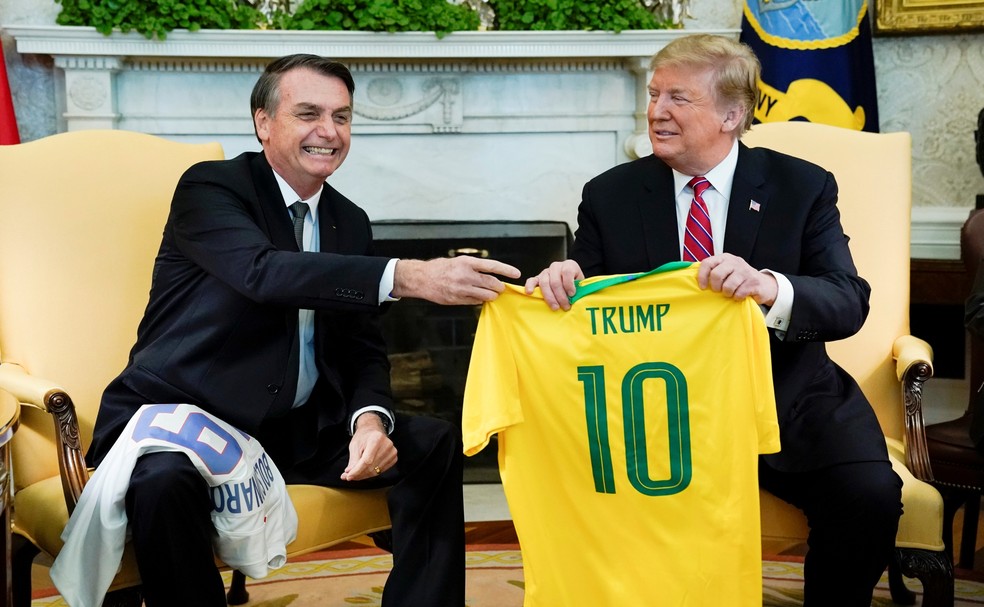 O presidente Jair Bolsonaro entrega camisa da SeleÃ§Ã£o Brasileira de futebol para Donald Trump; presidente norte-americano tambÃ©m presenteou Bolsonaro â Foto: REUTERS/Kevin Lamarque