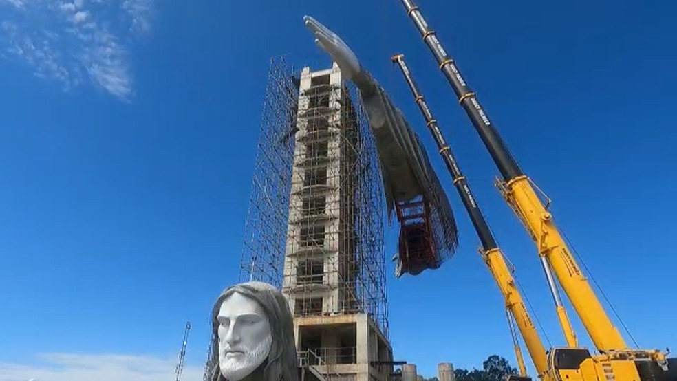 Guindastes erguem braços sobre estrutura da estátua do Cristo, em Encantado — Foto: Reprodução/RBS TV