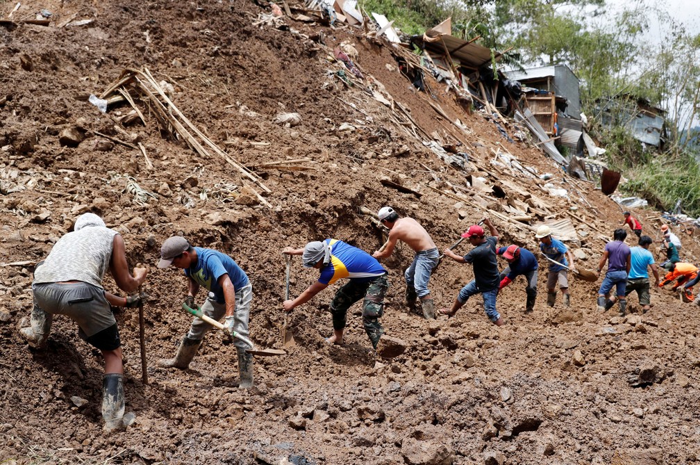 Socorristas trabalham nesta segunda-feira (17) em mina soterrada durante busca por mineiros que ficaram presos no local apÃ³s a passagem do tufÃ£o Mangkhut â€” Foto: Erik De Castro/Reuters