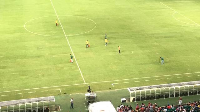 Funcionários da Arena Fonte Nova ajeitam o gramado durante o intervalo da partida