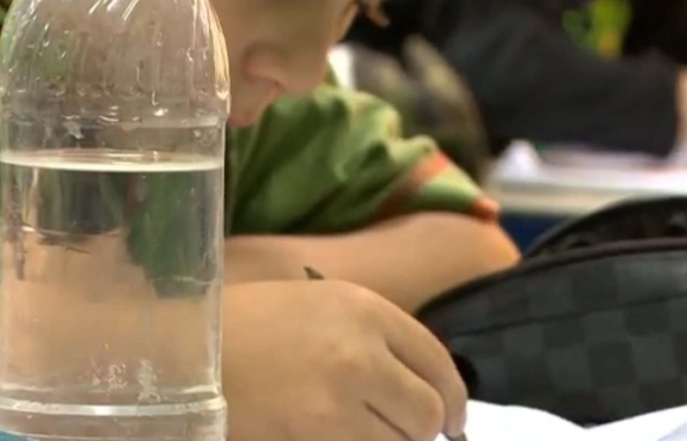 Crianças são orientadas a levar garrafas com água fervida para consumo na escola (Foto: Reprodução/RBS TV)