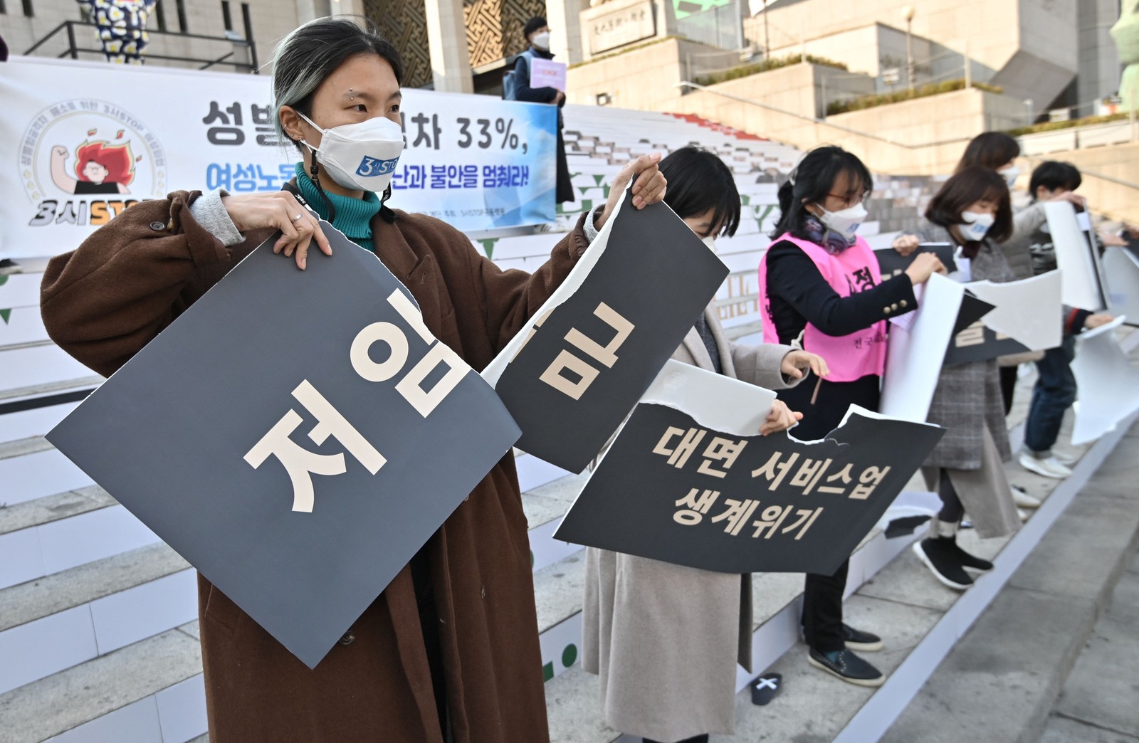 Ativistas sul-coreanas rasgam cartazes sobre discriminação contra mulheres durante um protesto para marcar o Dia Internacional da Mulher em SeulAFP