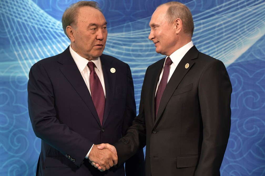 Os presidentes Nursultan Nazarbayev (Cazaquistão), à esquerda, e Vladimir Putin (Rússia) dão um aperto de mão no durante encontro na 5ª Cúpula do Cáspio, na cidade cazaque de Aktau (Foto: Alexey Nikolsky/Sputnik via AFP)