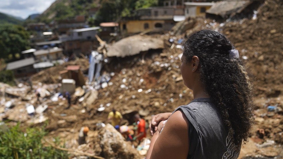 Priscila Neves observa a devastação no Morro da Oficina, uma das áreas mais atingidas pelo temporal em Petrópolis — Foto: Marcos Serra Lima/ g1