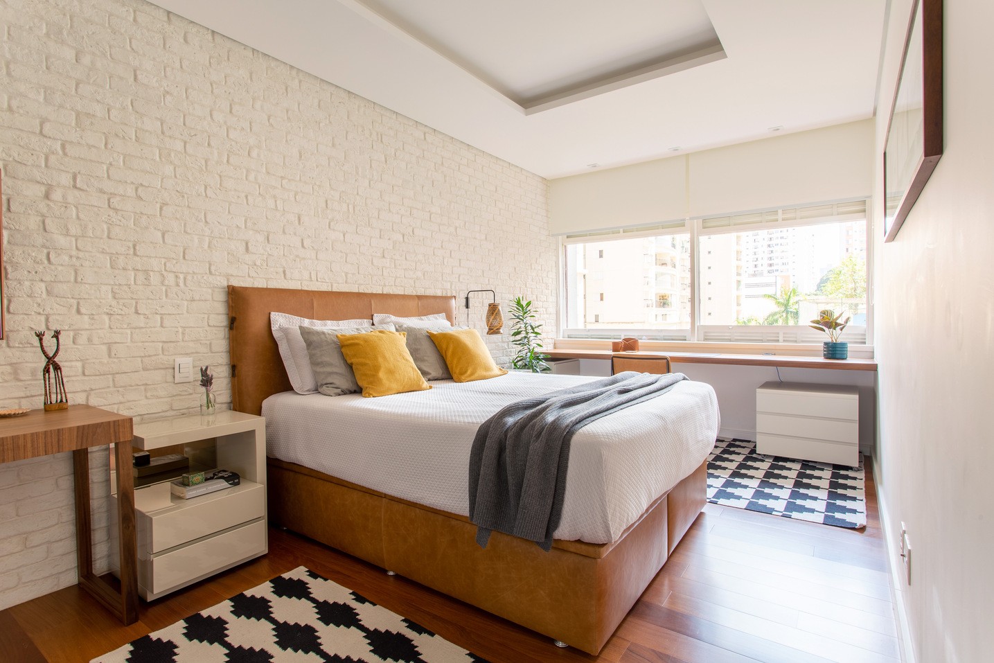 QUARTO | Na parede da cama, o tijolinho Brick Neve da Passeio. Sobre o piso de madeira cumaru, os tapetes da Koord  (Foto: Luiza Florenzano / Divulgação)