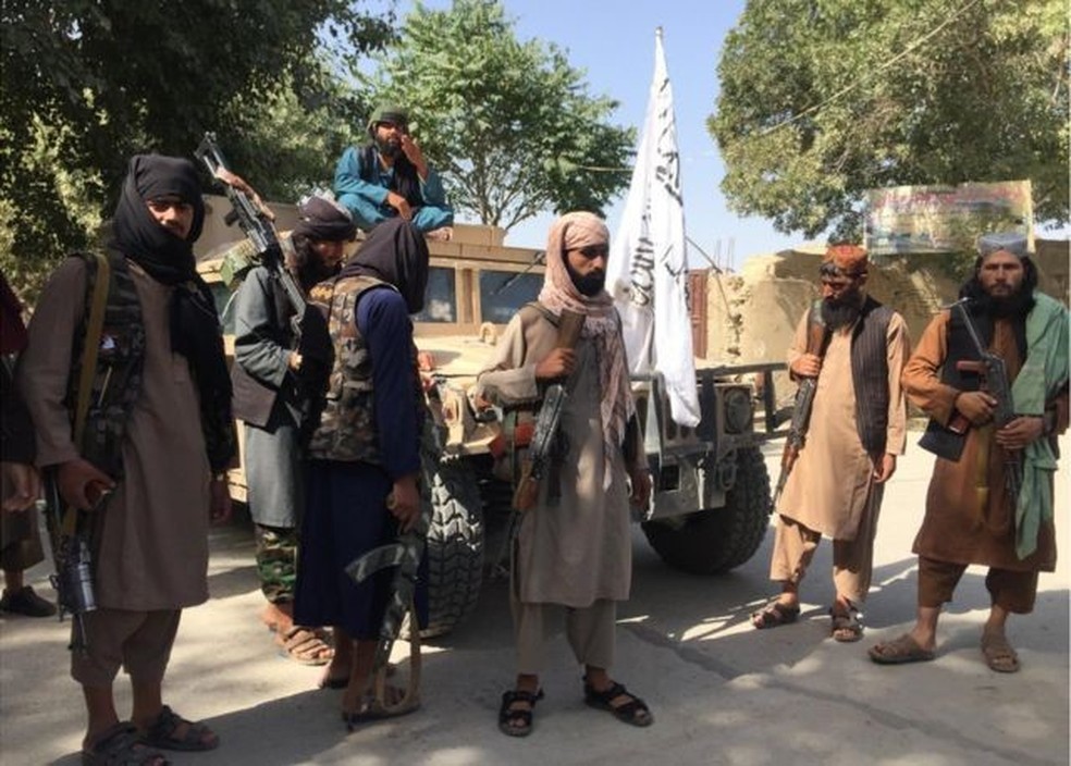 Combatentes do Taleban exibem o veículo utilitário militar Humvee que haviam capturado — Foto: BBC