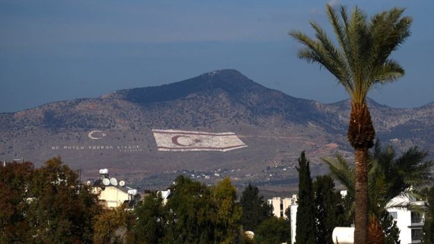 Bandeira da República Turca de Chipre do Norte pintada em uma montanha na cidade de Nicósia, capital do país - dividida ao meio pela Linha Verde (Foto: Getty Images/BBC)