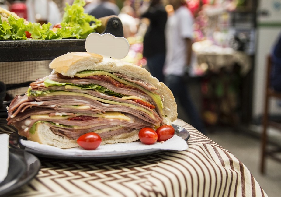O famoso sanduíche de mortadela, tradicional no Mercado Municipal de São Paulo, é uma das comidas típicas da gastronomia paulistana