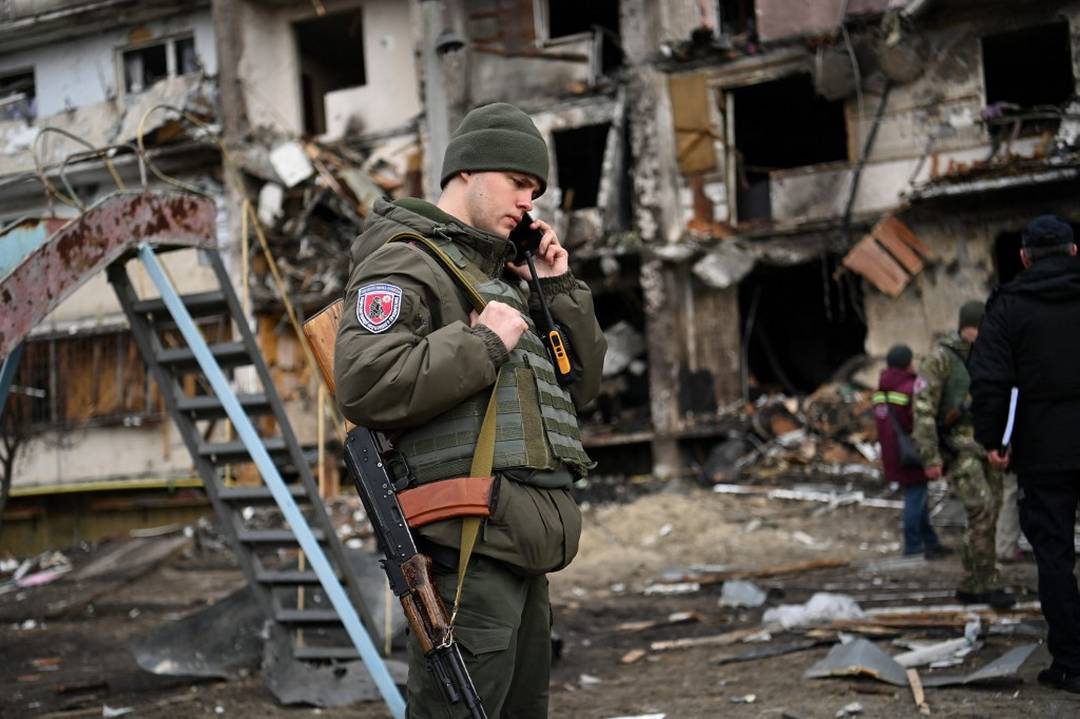 Militar ucraniano em frente a um prédio atingido em um subúrbio da cidade de Kiev, na Ucrânia