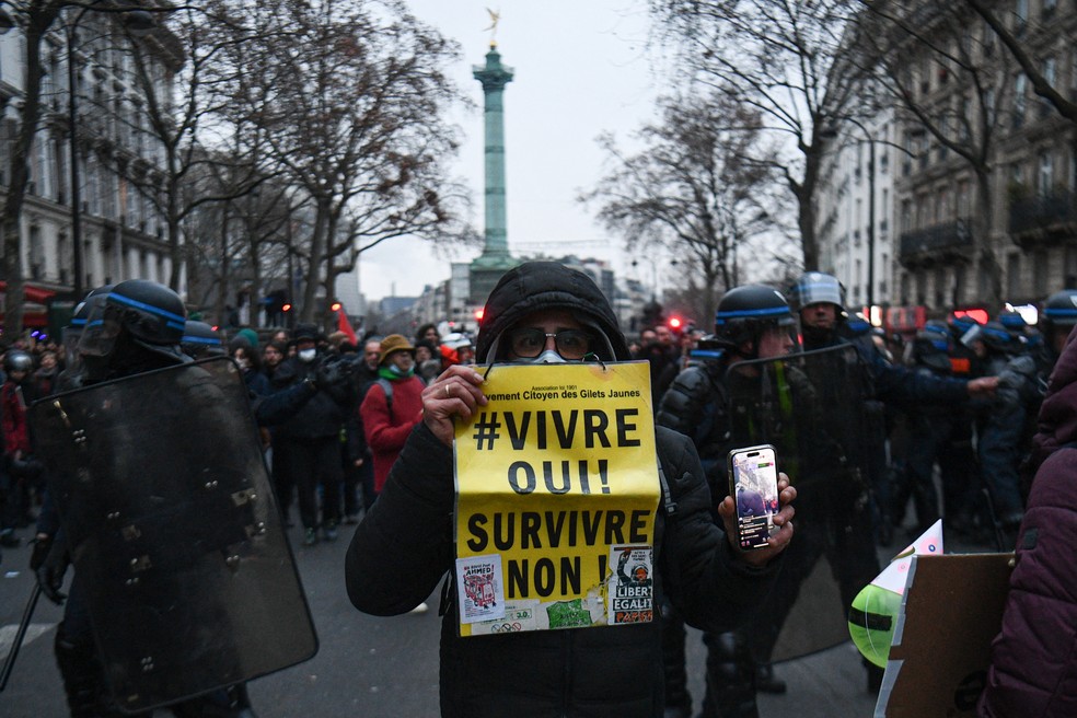 Manifestante segura cartaz com os dizeres ''viver, sim! sobreviver, não!' durante protestos em Paris, na França, em 19 de janeiro de 2023. — Foto: Christophe Archambault/ AFP