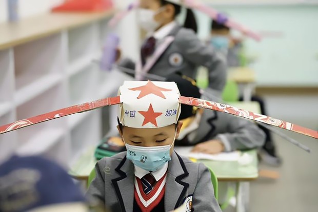 Crianças usam chapéu para manter distanciamento em escola na China (Foto: AsiaWire/Reprodução)