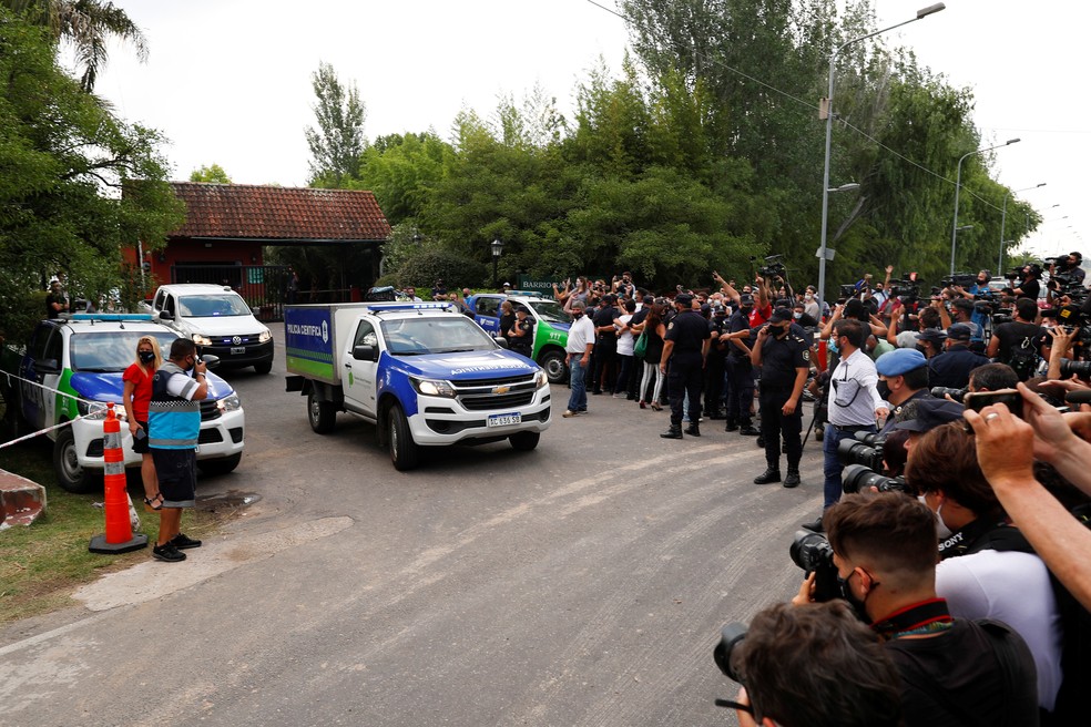 Jornalistas acompanham a saída do corpo de Maradona da casa em Tigre — Foto: Reuters