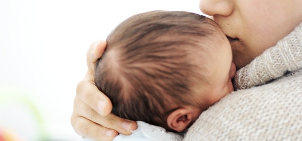 Bebê dormindo no colo da mãe (Foto: Shutterstock)