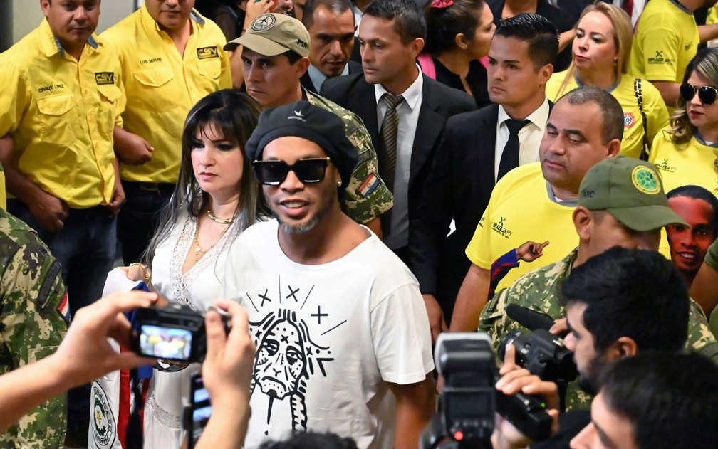 O ex-jogador Ronaldinho Gaúcho acena ao chegar ao Aeroporto Internacional Silvio Pettirossi, em Luque, perto de Assunção — Foto: Norberto Duarte / AFP Photo