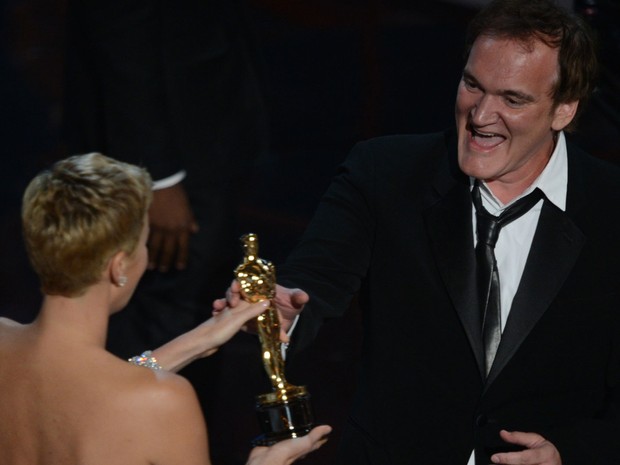 Quentin Tarantino recebe, das mãos de Charlize Theron, o Oscar de melhor roteiro original por 'Django livre' (Foto: Robyn Beck/AFP)