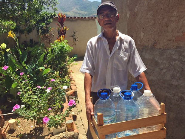Sebastião Lúcio, morador de Governador Valadares, busca água em poço artesiano duas vezes por semana. Ele não confia na água da rua após lama no Doce (Foto: Cida Alves/G1)